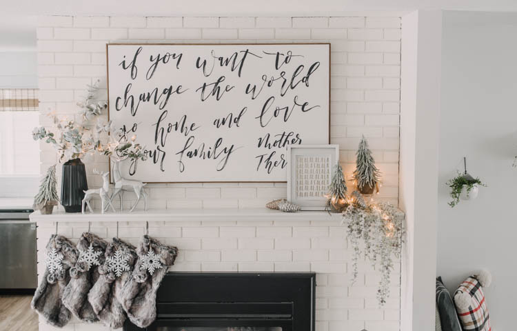 Modern holiday mantel decor... full of black, white, metallics, and frosted greenery