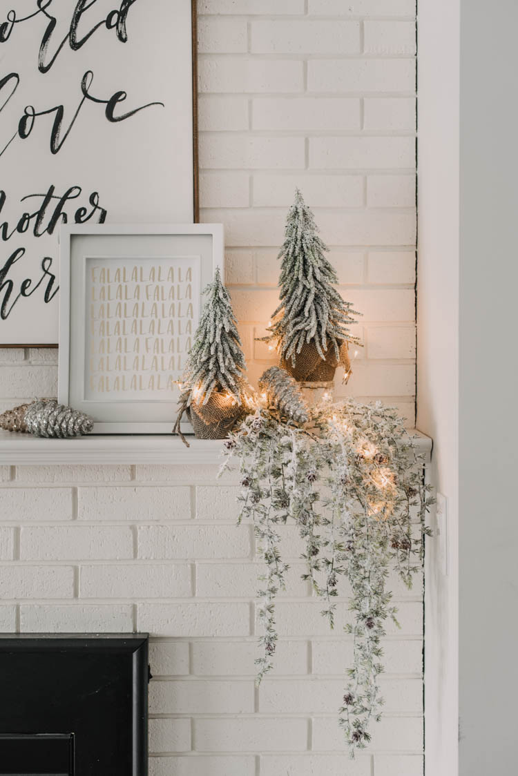 Modern holiday mantel decor... full of black, white, metallics, and frosted greenery