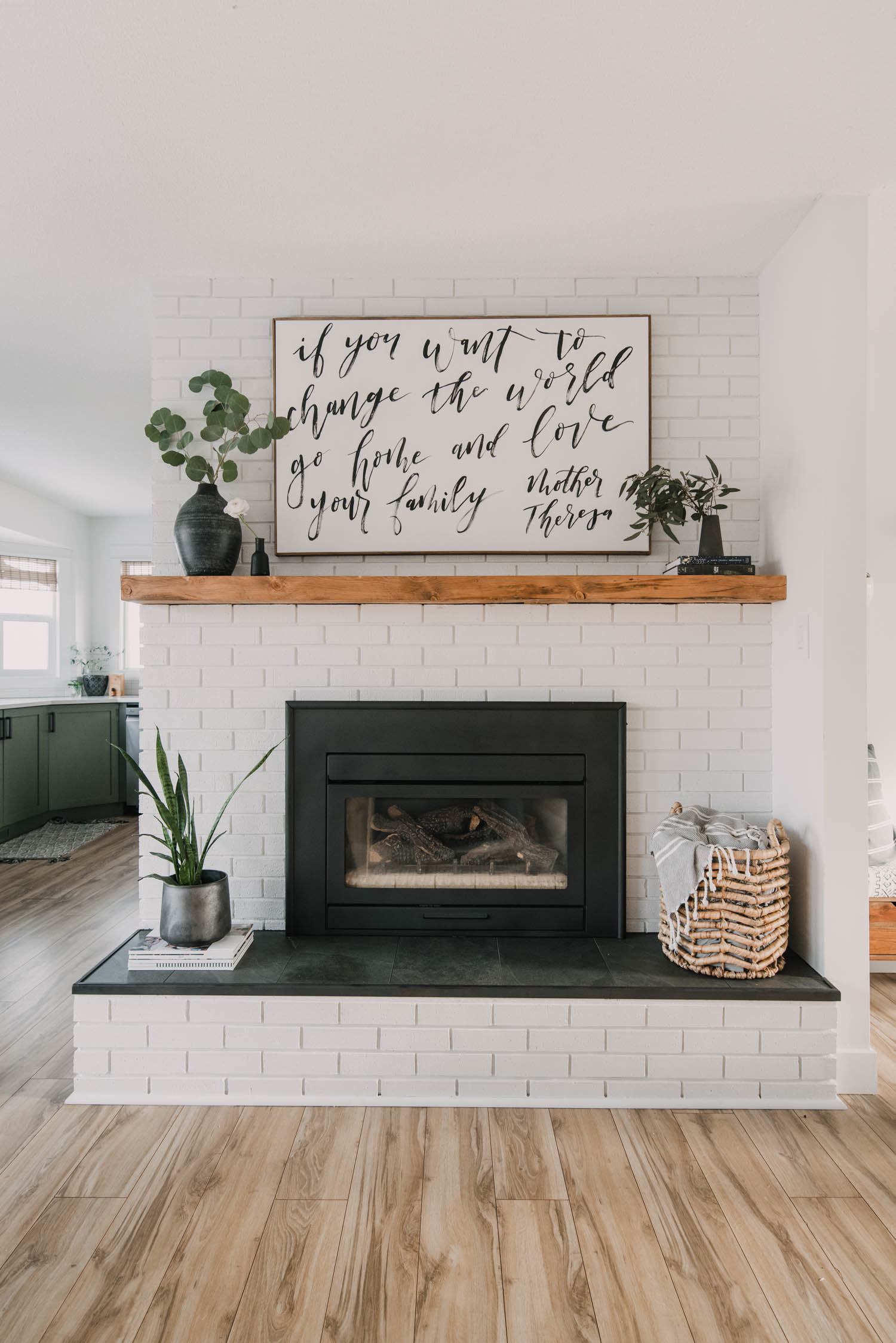 Painted brick fireplace with rustic wood mantel and tile hearth