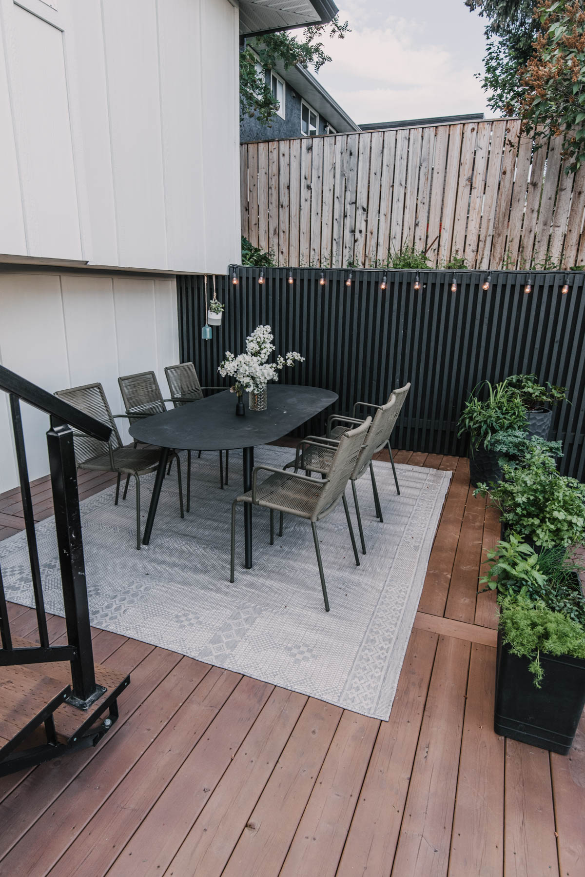 A grey and washable outdoor rug under a dining table on the deck.