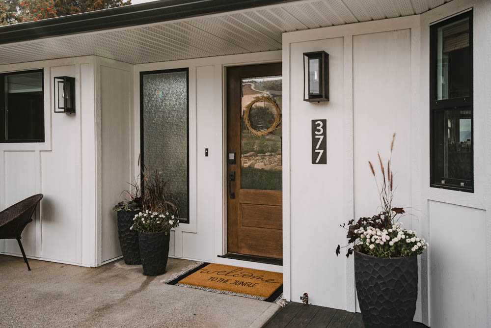 Modern white home exterior with black windows and lights