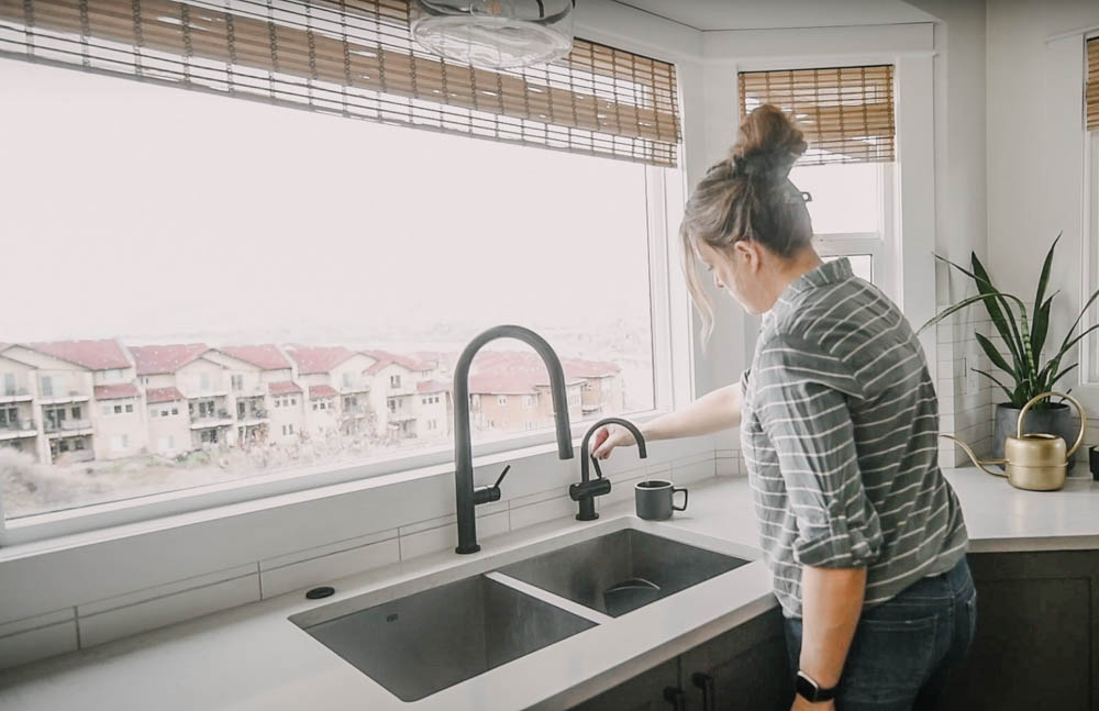 Modern black hot water dispenser in use