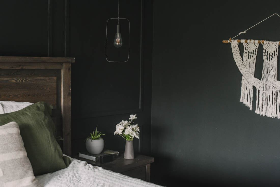 Black moulding wall with pendant lights over nightstand