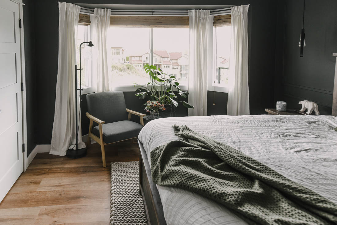 Black bedroom decor with a cozy bay window