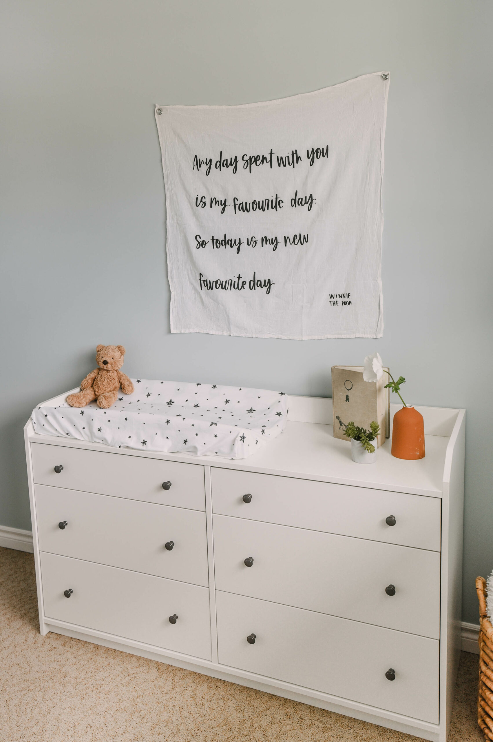 Modern Winnie The Pooh Decor- white wall hanging on light blue wall with hand lettered winnie the pooh quote