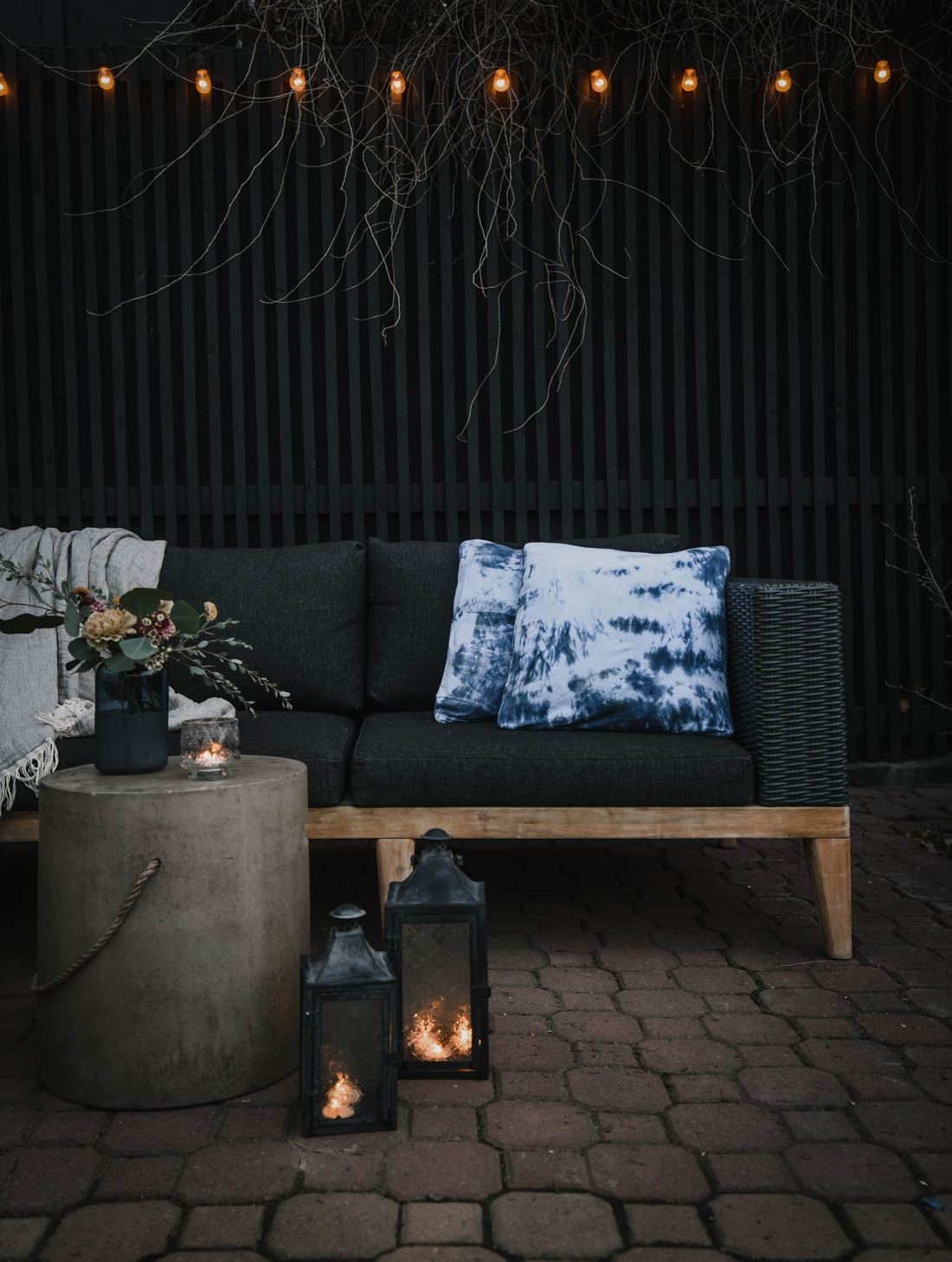 Moody brick patio with tie dye and a charcoal sectional