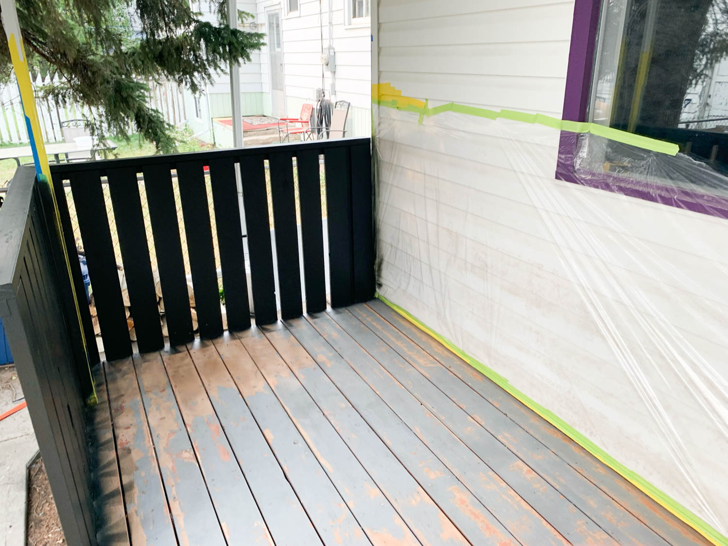 Painting a deck railing with a paint sprayer