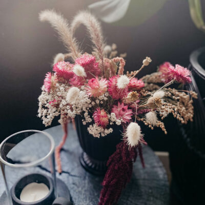 dried floral arrangement with pink strawflowers and bunny tail grasses