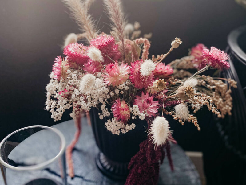 dried floral arrangement with pink strawflowers and bunny tail grasses