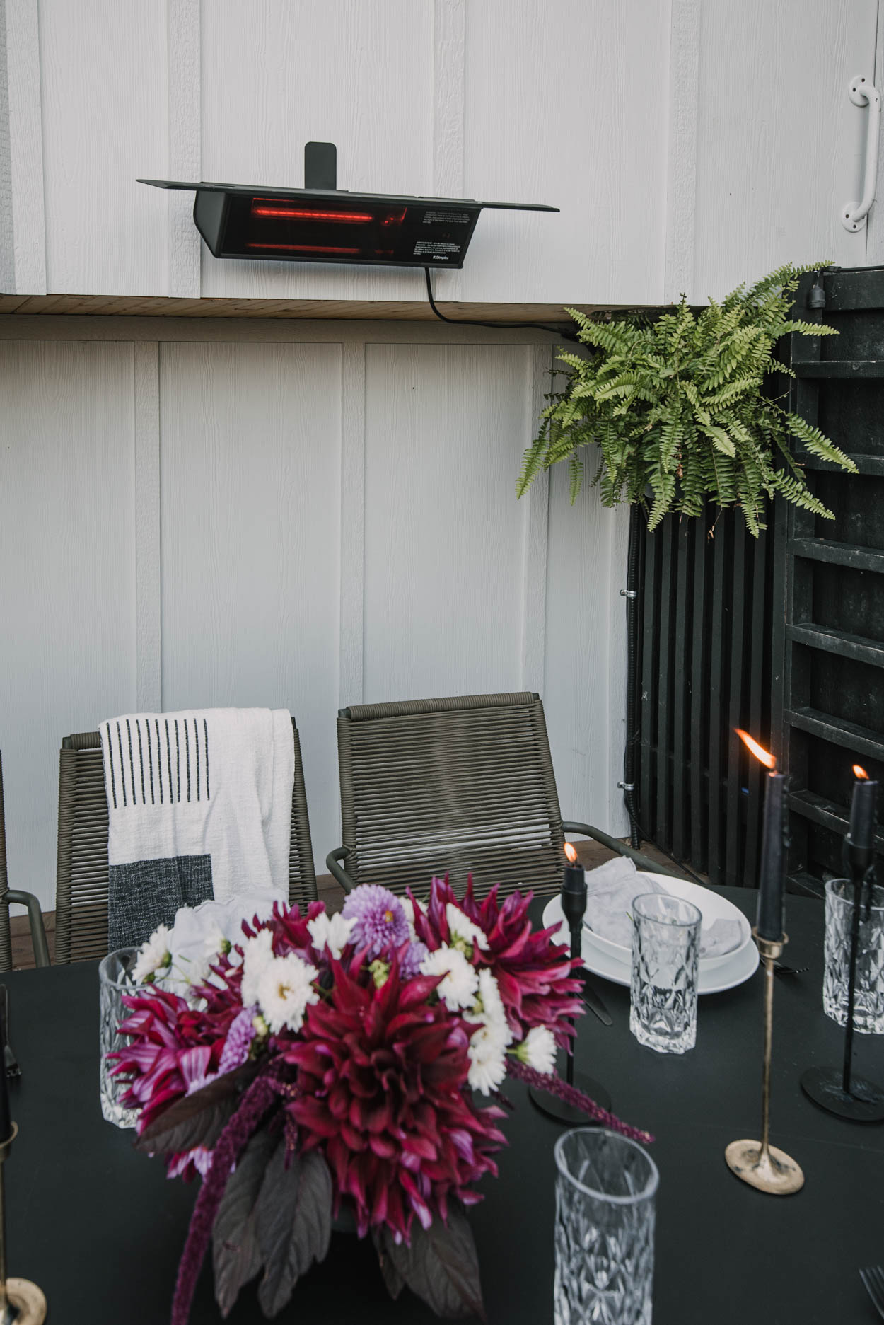 floral arrangement on outdoor dining table surrounded by candles