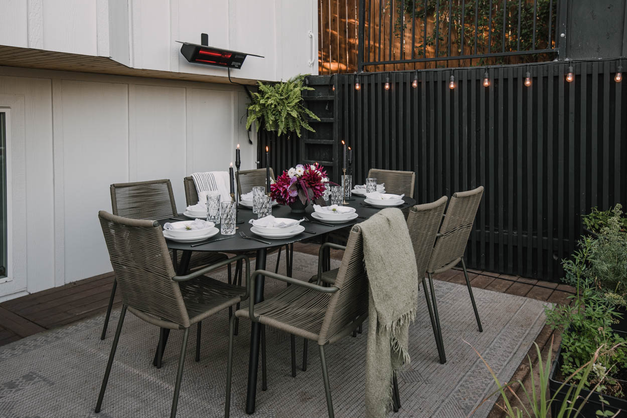 A dining table with an outdoor washable rug underneath.