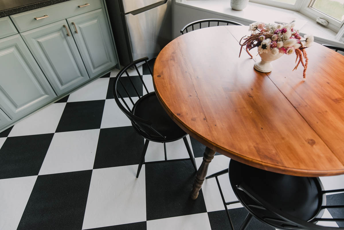 Checkerboard floors in a blue kitchen with wood and brass details