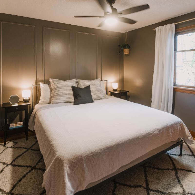 taupe bedroom with DIY picture frame moulding on the headboard wall.