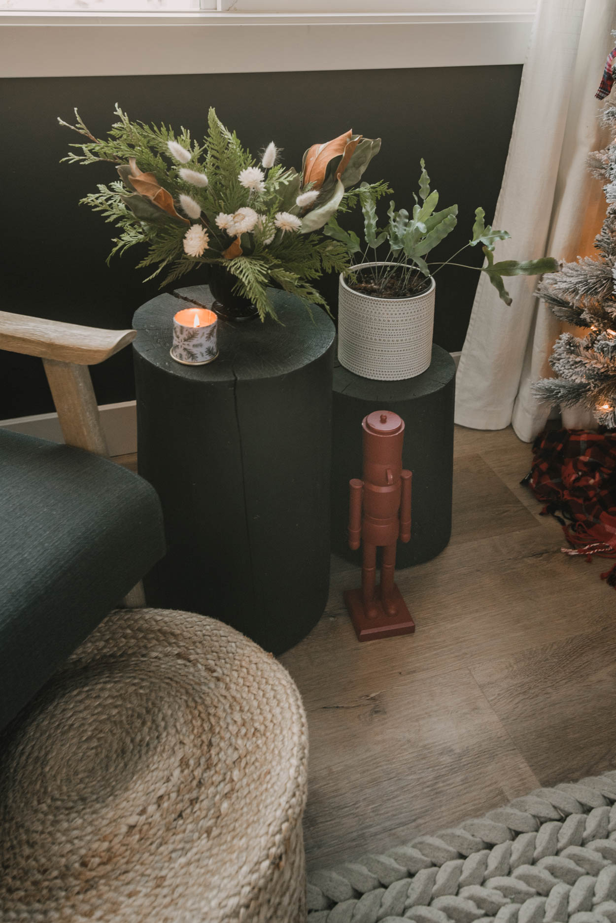 Holiday bedroom decor - bay window sitting area with log tables, nutcracker and holiday floral arrangement