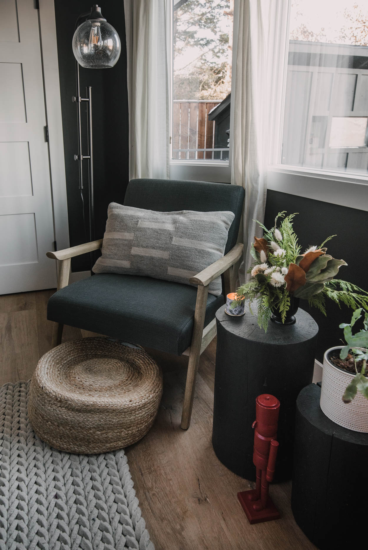Holiday bedroom decor - bay window sitting area with log tables, nutcracker and holiday floral arrangement