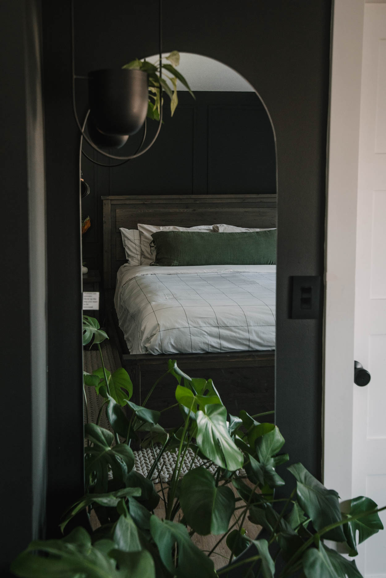 Cozy black bedroom update- view through mirror of bed