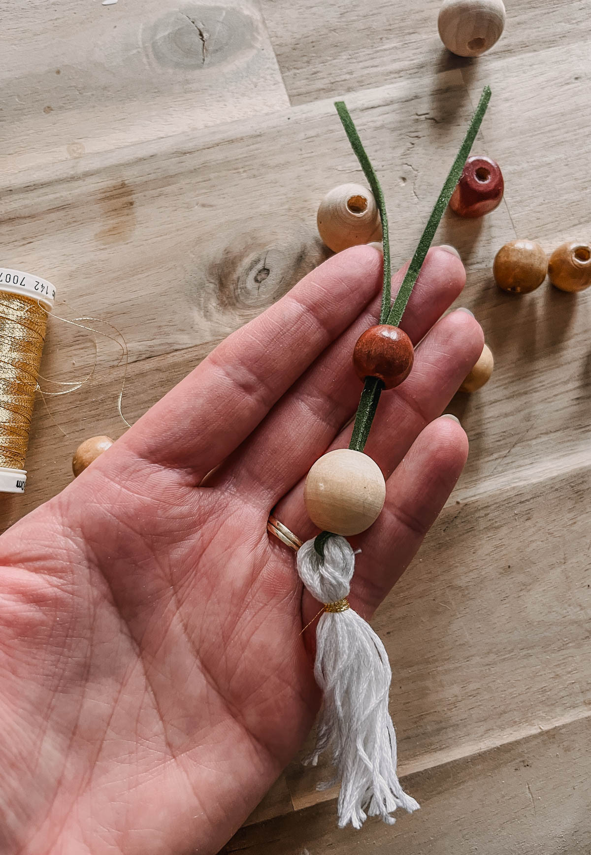 Adding wooden beads to a tassel for a simple christmas ornament