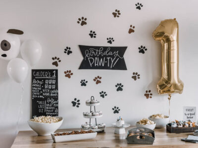 First birthday party with a puppy theme- paw print backdrop behind party table
