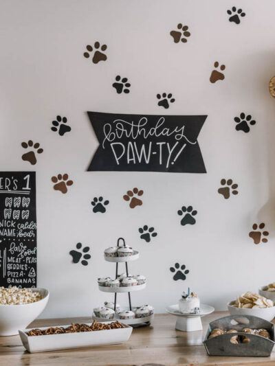 First birthday party with a puppy theme- paw print backdrop behind party table