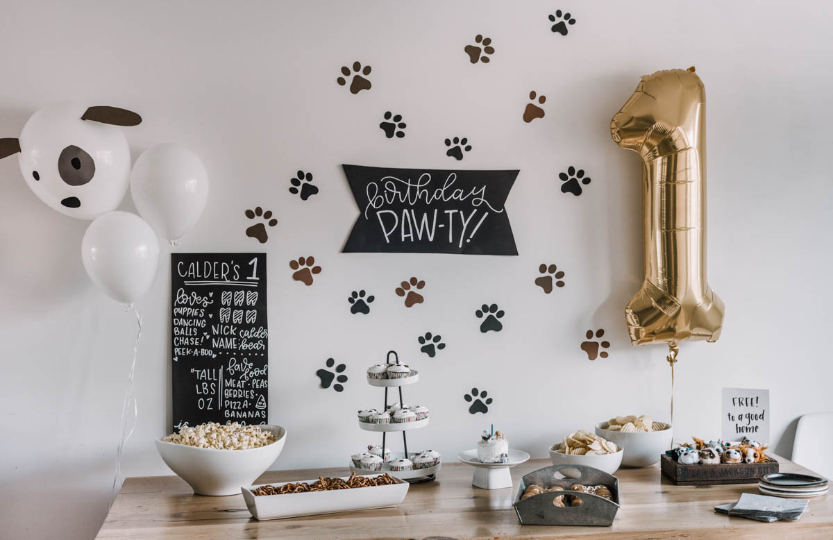 First birthday party with a puppy theme- paw print backdrop behind party table