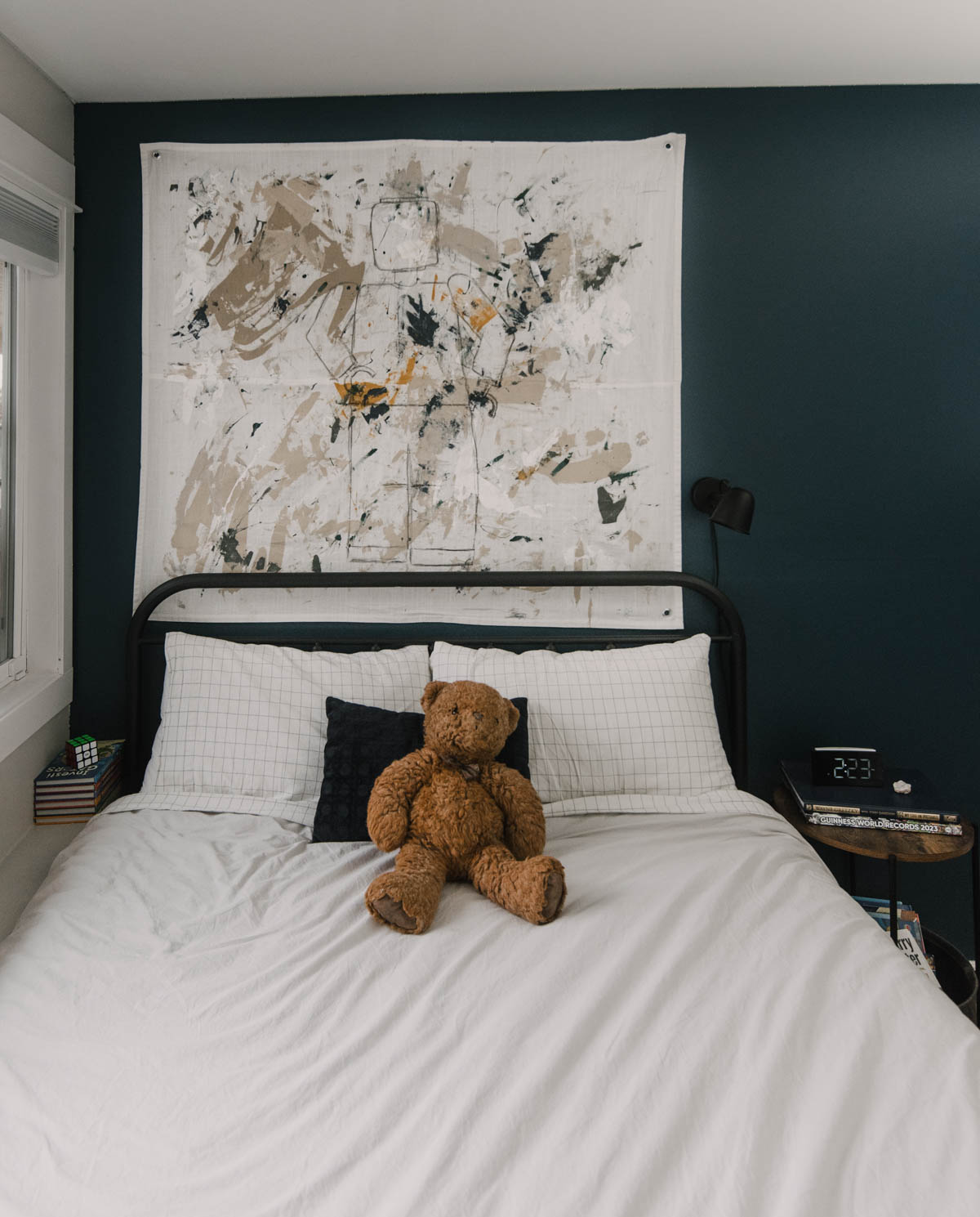 Tween boys bedroom makeover with white bedding and navy walls