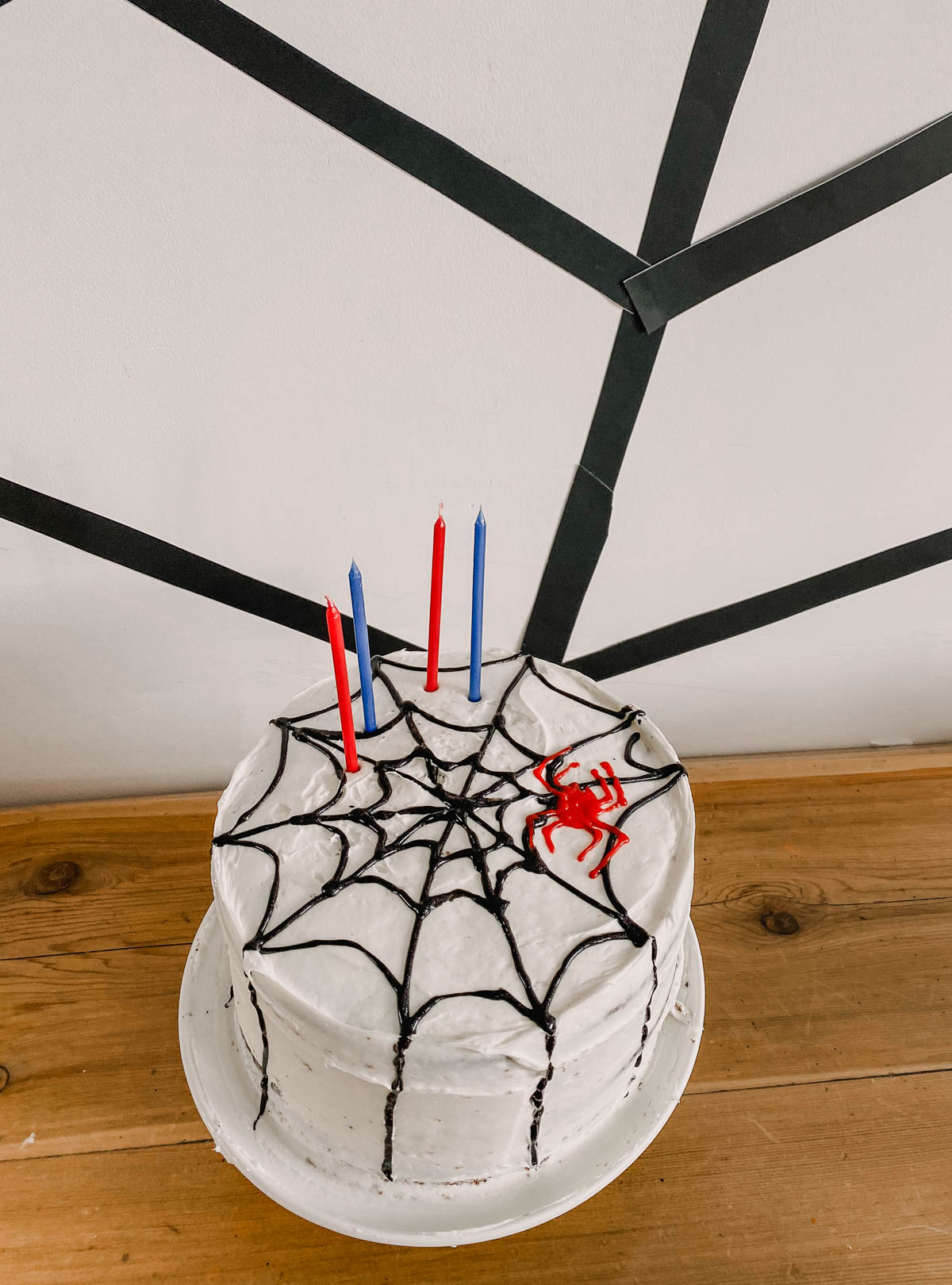 DIY Spiderman themed cake, white cake with black spiderweb gel icing and red spider