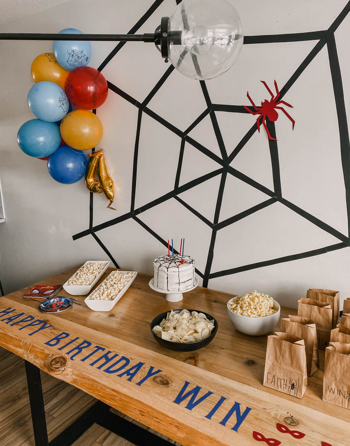 DIY Spiderman party decor, giant spiderweb and a bunch of balloons as a backdrop