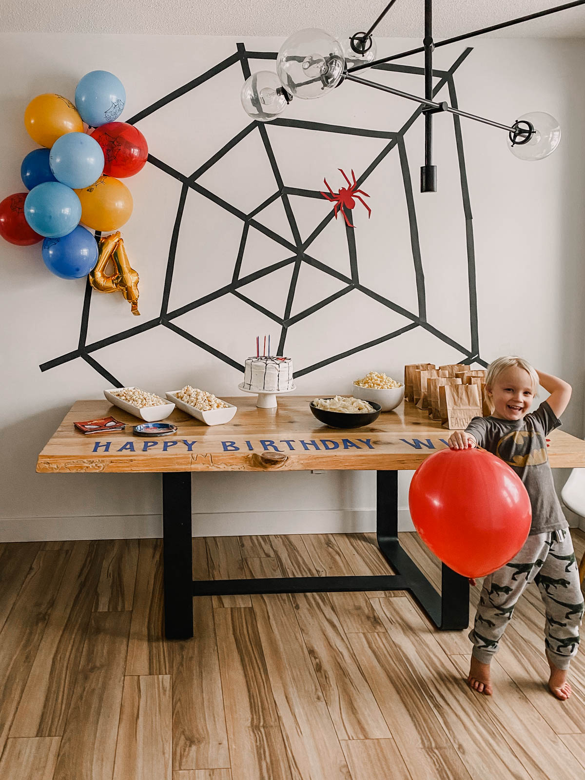 DIY Spiderman birthday party decor- large spiderweb backdrop and some balloons