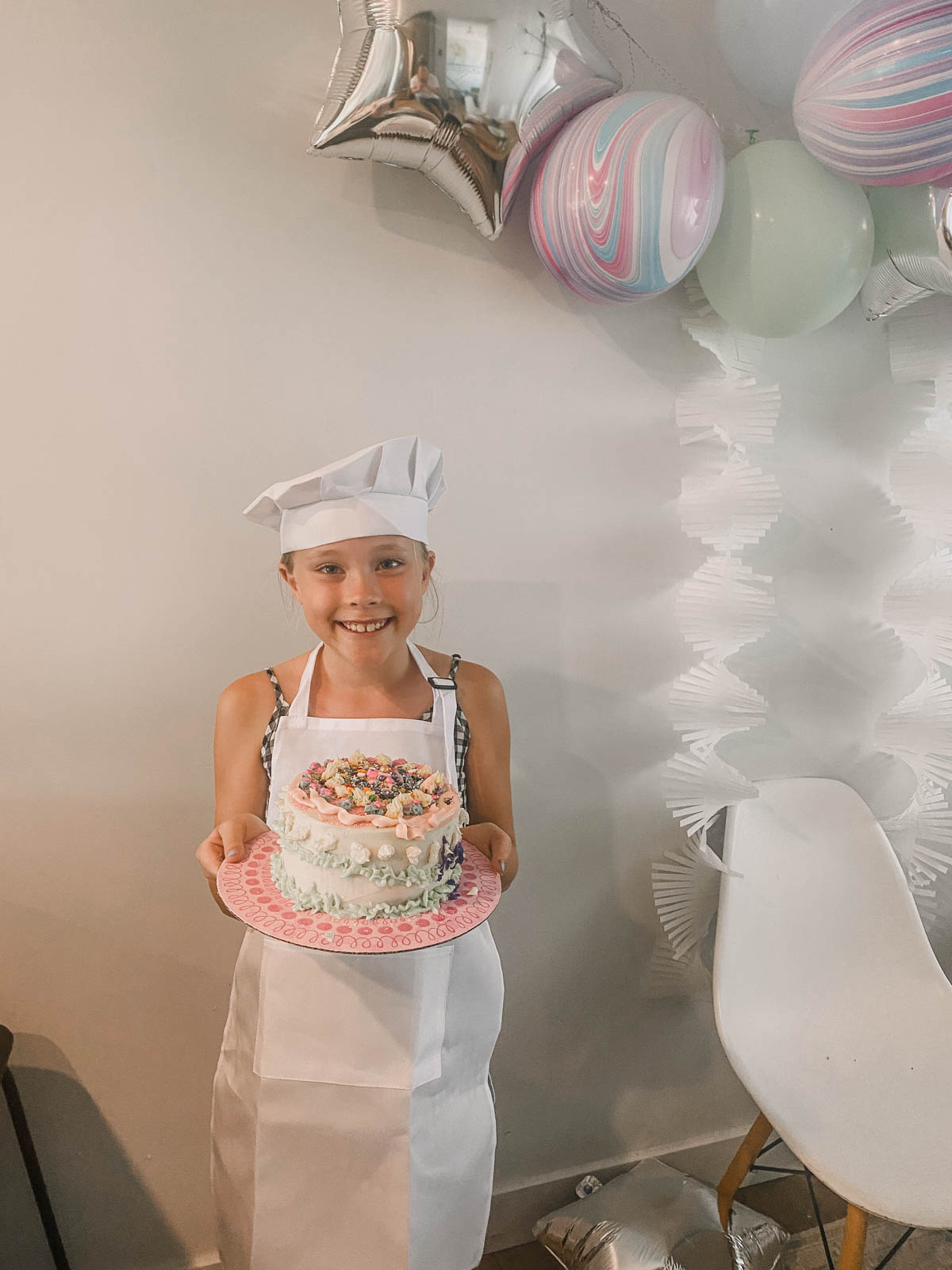 girl holding cake she decorated at a cake decorating party