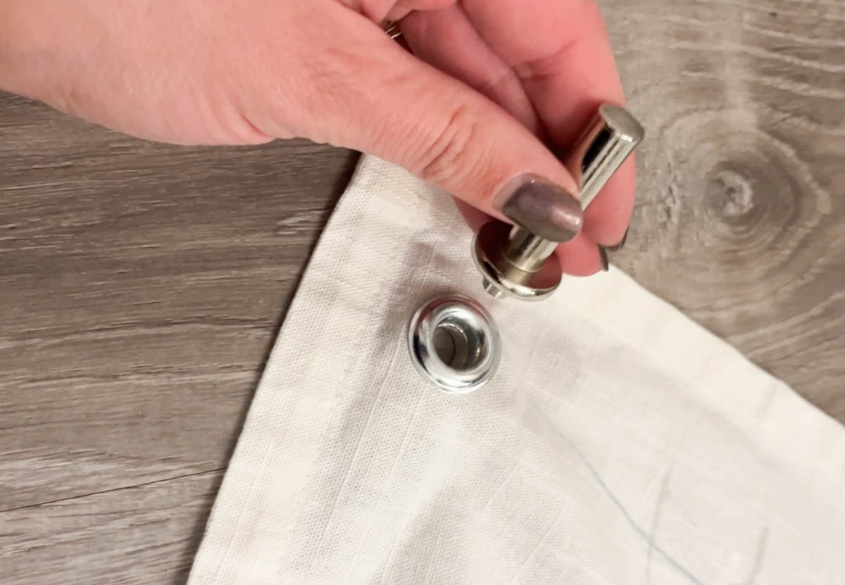 adding a grommet to the corners of a diy wall flag