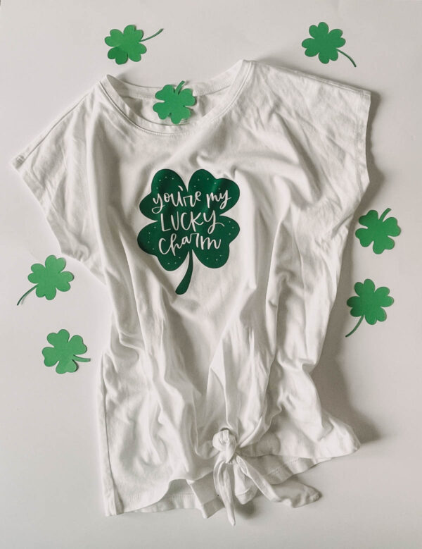 'you're my lucky charm' hand lettered on a shamrock ironed on to a tee shirt