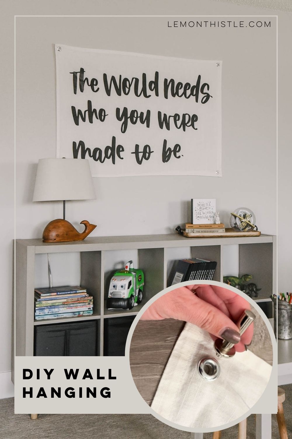 Image of a playroom giant wall hanging that says 'the world needs who you were made to be' with image overlay of a grommet being set in the corners of the wall hanging to be hung. Text title reads: DIY Giant WAll Hanging 