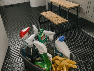 plastic caddy full of bathroom cleaning supplies on bathroom floor