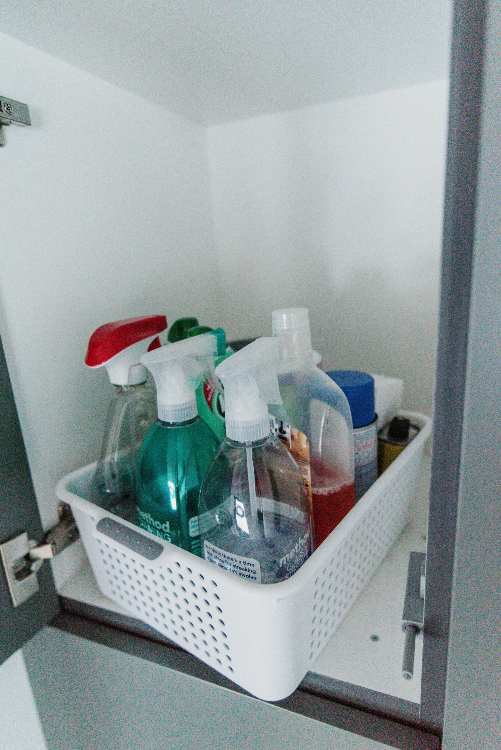 cleaners in a basket in a top cupboard