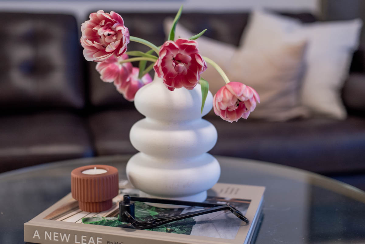 Simple spring decorating- vase of tulips with a small candle on a coffee table book