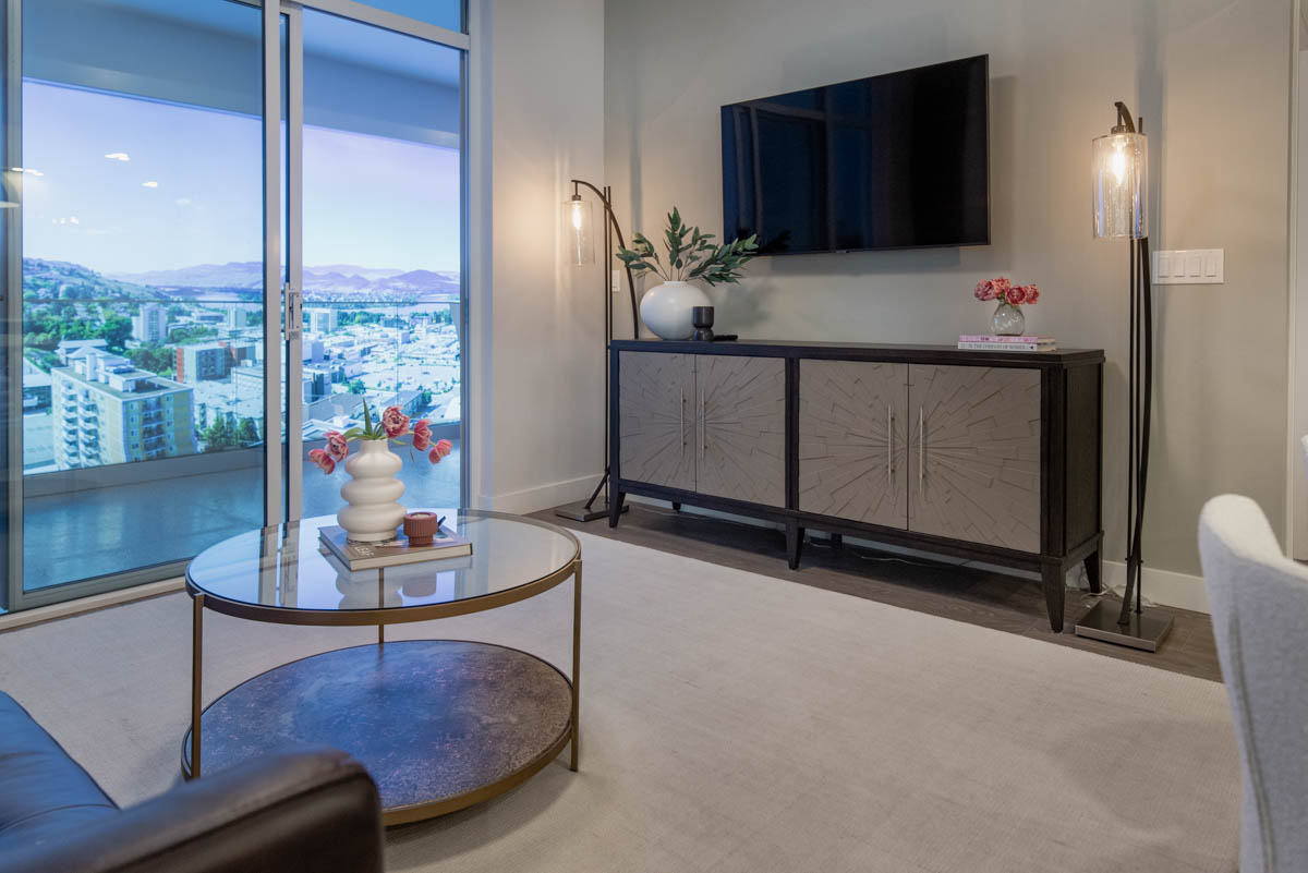 Simple spring decor in a modern contemporary living room- base of faux branches on side table and smaller vases of tulips on stacked books