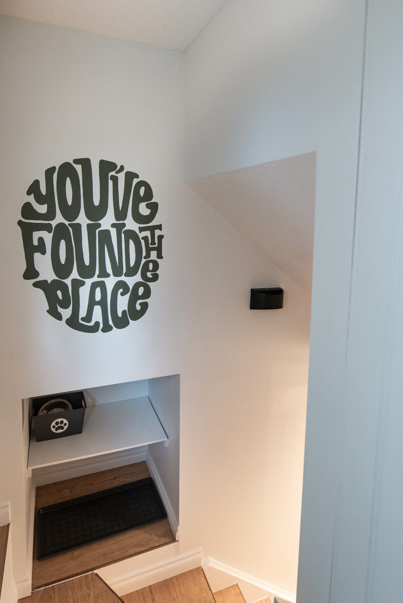 Entryway mural with retro vibes reads 'you've found the place'