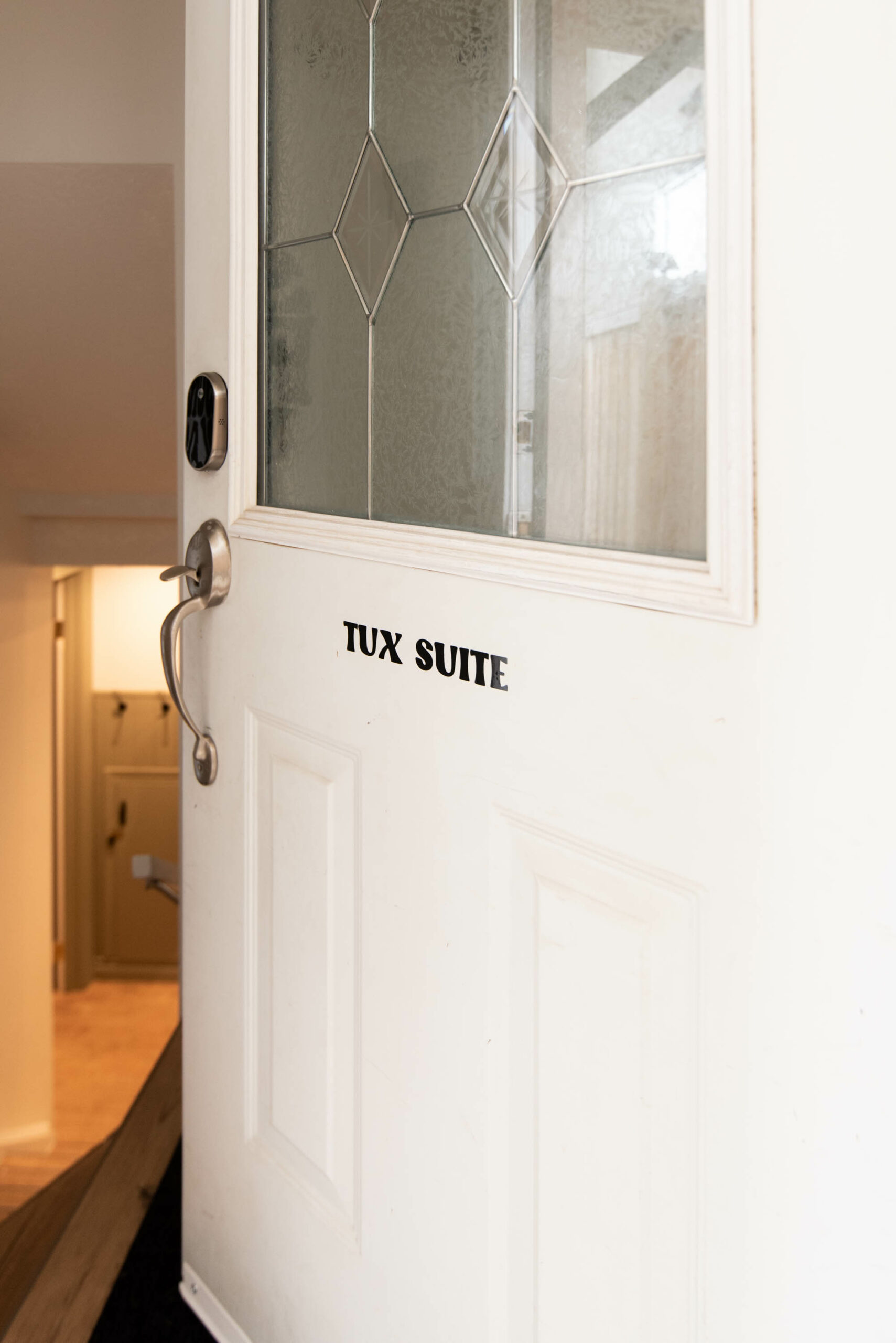 Cozy hideaway 'tux suite' labelled on door to a basement suite rental