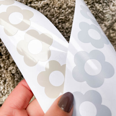 What is the best vinyl to use for my decals? a comparison- image of two sheets of flower decals, one in clay glossy permanent adhesive vinyl, one in light blue matte removable adhesive vinyl