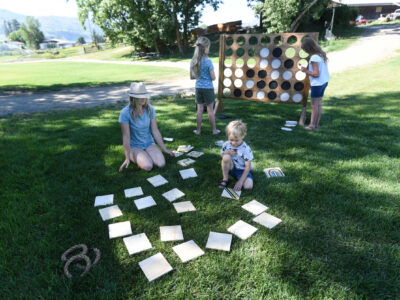 family playing outdoor yard games like giant connect 4 and memory
