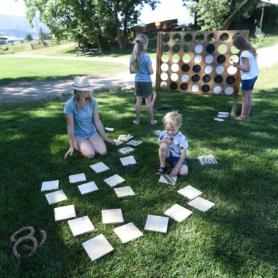 family playing outdoor yard games like giant connect 4 and memory