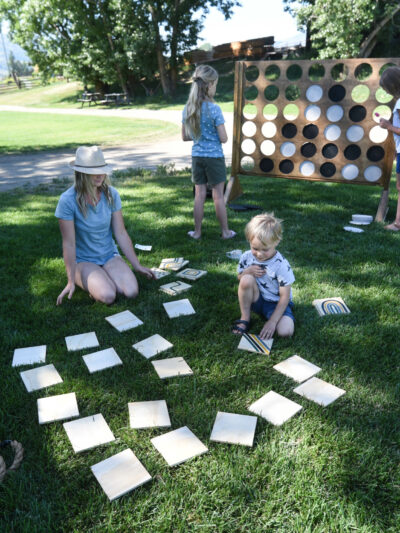 family playing outdoor yard games like giant connect 4 and memory