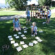 family playing outdoor yard games like giant connect 4 and memory