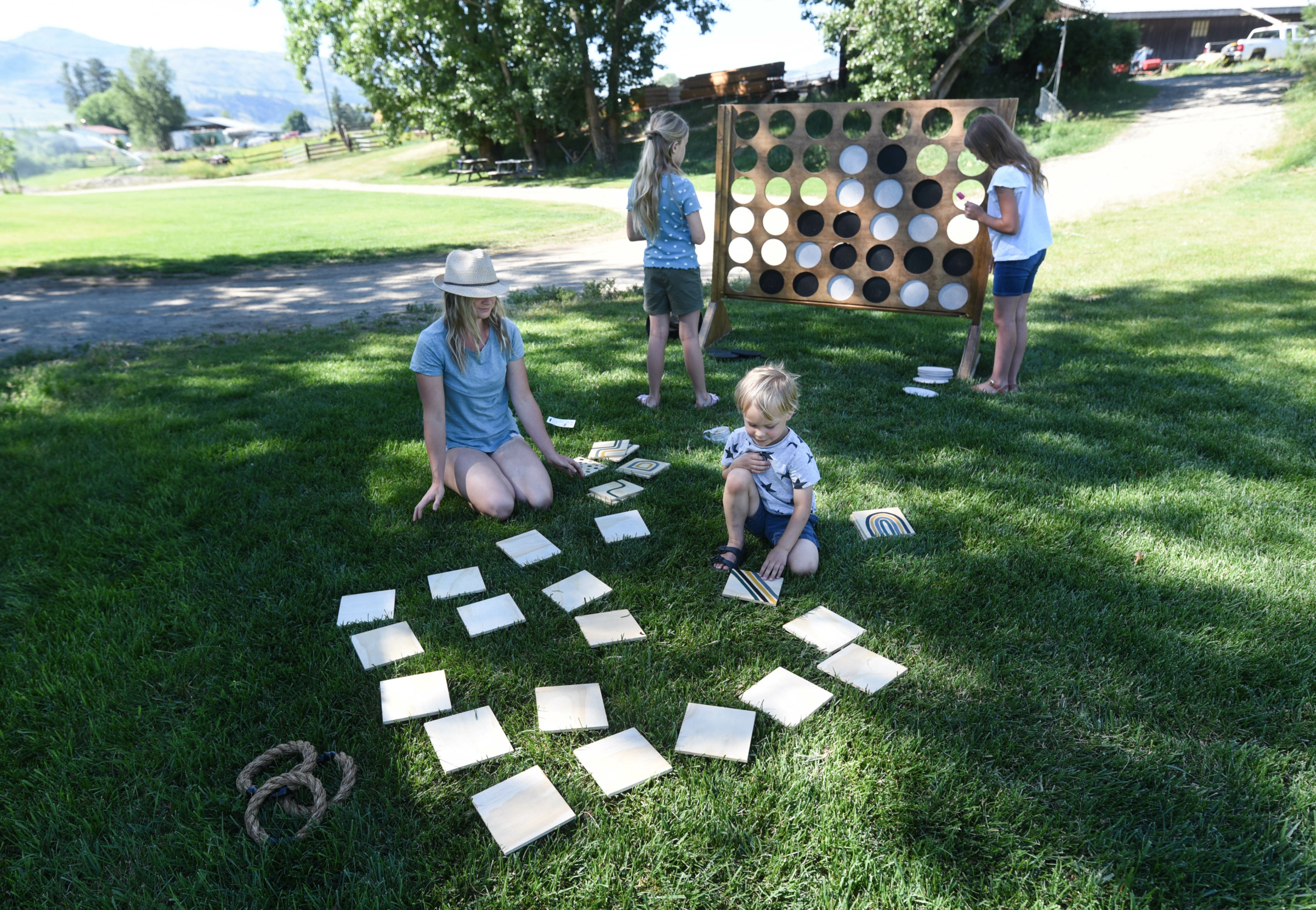 family playing outdoor yard games like giant connect 4 and memory