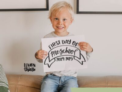 image of young boy holding a 'first day of kindergarten 2024-2025' sign text over reads 'free printable signs, updated yearly!' from lemonthistle.com