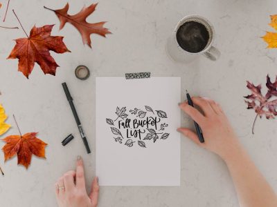 Free Printable Fall bucket lists with ideas (image of printed bucket list template and hands ready to fill in the list