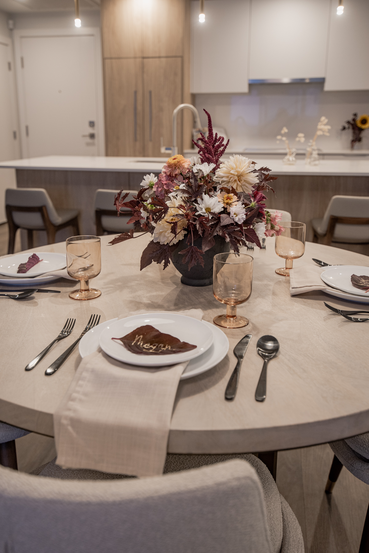 Classic fall tablescape with floral centerpiece and dark leaf with gold lettering for place card