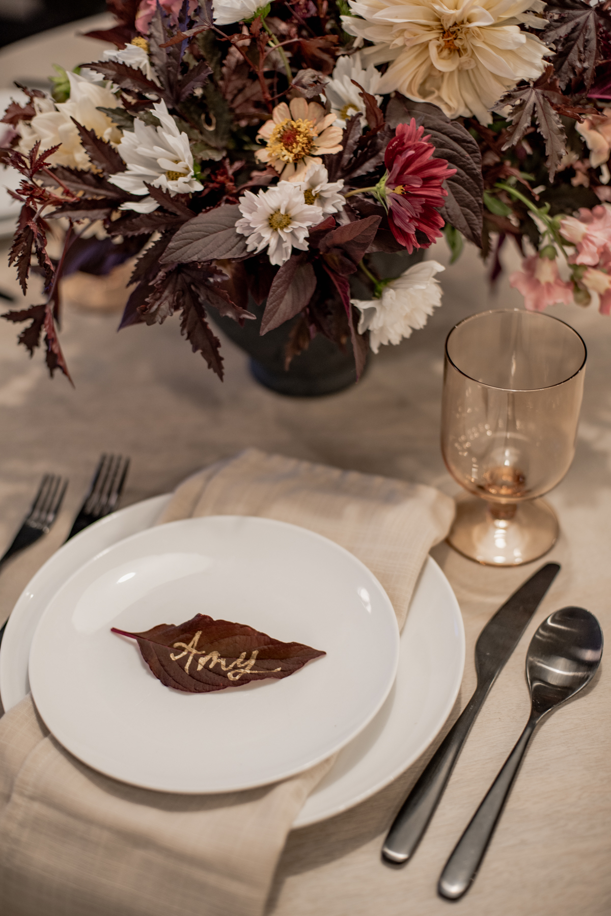 Fall Tablescape with gold lettering on a dark leaf for each place setting