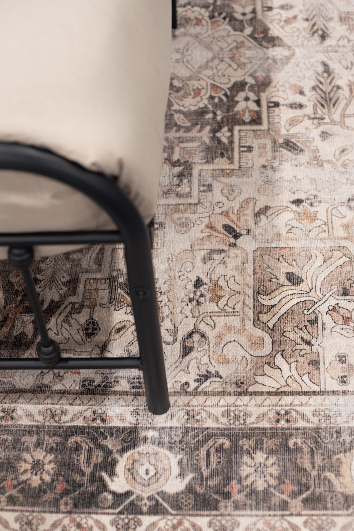 Medallion rug with a metal bed in a moody green bedroom