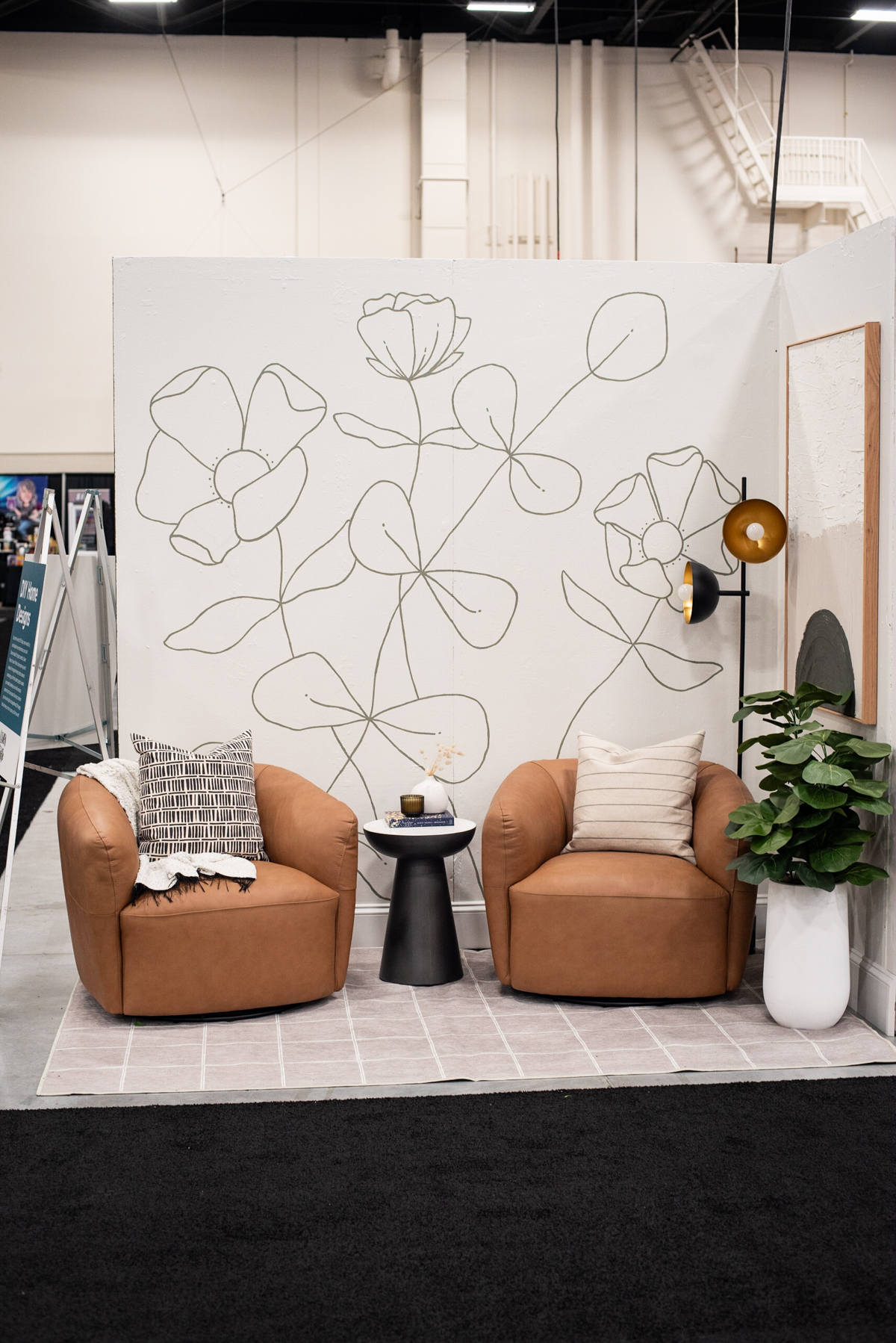 Sitting area with leather chairs and hand painted floral mural at the calgary home show designed by diy blogger colleen pastoor